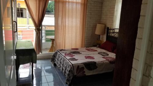 a bedroom with a bed and a large window at Zihua 360 in Zihuatanejo
