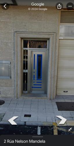 a front door of a building with a blue door at Piso camino a Fisterra in Negreira