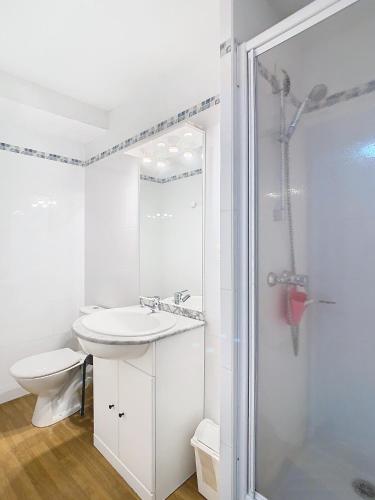 une salle de bain blanche avec un lavabo et une douche dans l'établissement Appartement 2 chambres en duplex à La Mongie, à La Mongie
