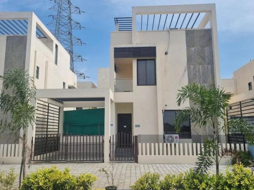 a white house with palm trees in front of it at ECR 2 Relaxing Modern 3BHK Villa Private Pool in Tirupporūr