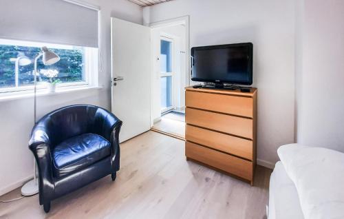 a bedroom with a black chair and a television at Stunning Apartment In Skagen With Wifi in Skagen