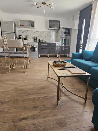 un salon avec un canapé bleu et une table dans l'établissement Appartement en bord de seine, à Le Coudray-Montceaux