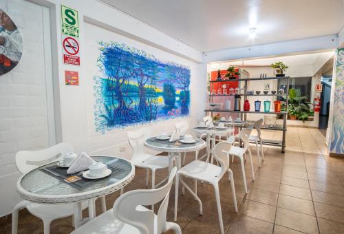 a restaurant with tables and chairs and a painting on the wall at Magdalen House in Lima