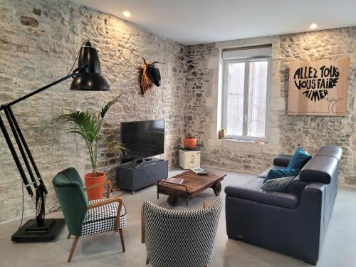 un salon avec un canapé et une télévision dans l'établissement L'atypique des arènes, à Nîmes