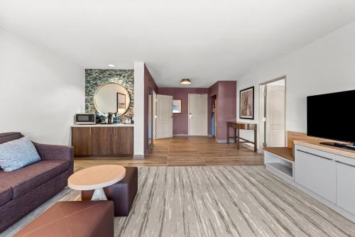 a living room with a couch and a tv at Hilton Garden Inn Seattle North/Everett in Mukilteo
