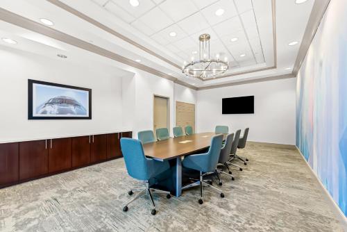 a conference room with a wooden table and blue chairs at Hilton Garden Inn Seattle North/Everett in Mukilteo