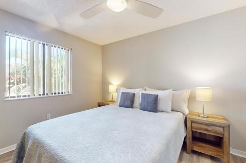 a bedroom with a white bed with two night stands and a window at SEA STAR in Cape Canaveral