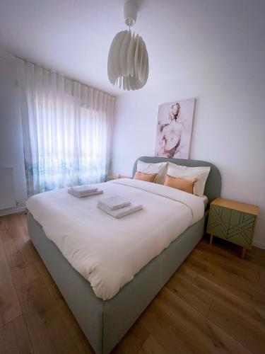 une chambre avec un grand lit avec des draps et des oreillers blancs dans l'établissement Grand appartement, à Clichy