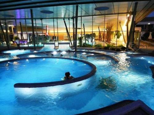 - une grande piscine dans un bâtiment avec une personne dans l'établissement Albert Ranch House - Grande maison au calme - Parking, à Ribeauvillé