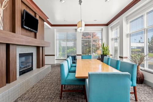 a dining room with a table and chairs and a fireplace at Hilton Garden Inn Seattle North/Everett in Mukilteo