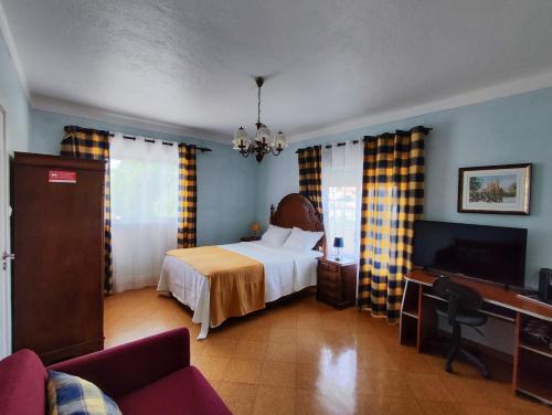 a hotel room with a bed and a television at Casa Maria in Loures