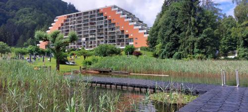 a large building next to a body of water at Apartment mit Seeblick & Seezugang in Villach