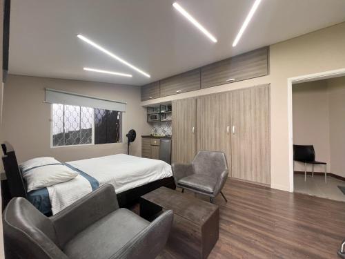 a bedroom with a bed and a table and chairs at Hospedaje cerca a centro comercial de Santafé A104 By Roots Rentals in Medellín