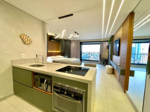 eine Küche mit Spüle und ein Wohnzimmer mit Bett in der Unterkunft Luxury Collection Cama Queen e Sofá Cama Separado in Campo Grande