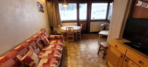 a living room with a couch and a table and a television at Résidence Makalu - Studio divisible 4 personnes Plagne Centre MAE-3484 in Aime La Plagne