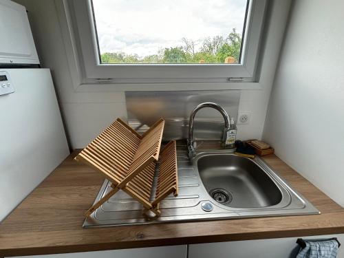 un évier dans une petite cuisine avec une fenêtre dans l'établissement La Tiny du Rougy, à Frolois