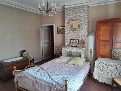 une chambre avec un lit et un lustre dans l'établissement Antique maison de montagne en ville !, à Briançon