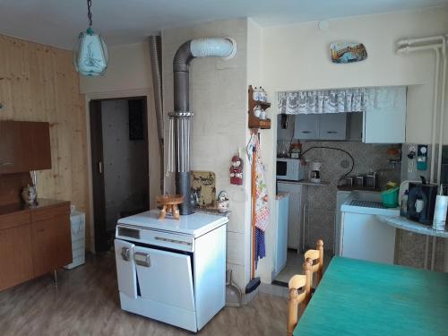 une cuisine avec une cuisinière et une table à l'intérieur dans l'établissement Antique maison de montagne en ville !, à Briançon