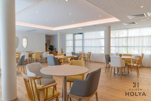 une salle à manger avec tables, chaises et fenêtres dans l'établissement Aux cœur de Limoges - Le Délicat - 370B, à Limoges