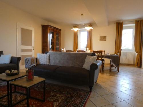 un salon avec un canapé et une table dans l'établissement Gîte familial à Vald'Yerre : détente, jeux et charme rural pour 8 personnes - FR-1-581-120, à Boisgasson