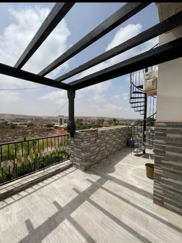 a pergola on a balcony of a house with a view at Marina AP8 in Saidia 