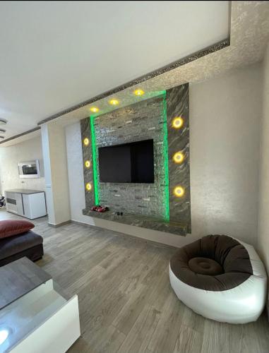 a living room with a fireplace with a tv and a couch at Marina AP8 in Saidia 