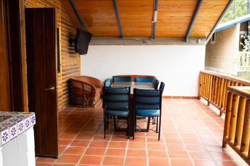 a patio with a table and chairs on a porch at Cabañas Bungalos las Alazanas in San Antonio de las Alzanas