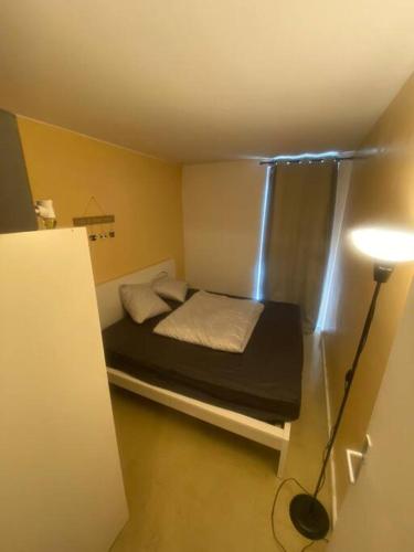 - une petite chambre avec un lit et une lampe dans l'établissement T2 Chevilly-Larue proche Metro 14, à Chevilly-Larue
