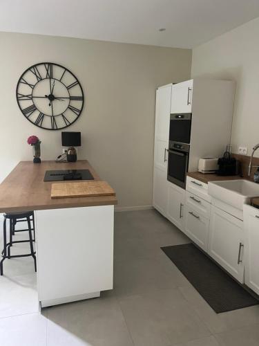 a kitchen with a large clock on the wall at Maison au bord de la Loire in Saint-Jean-le-Blanc