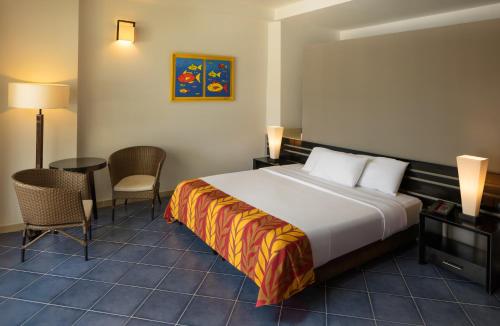 a hotel room with a bed and a table and chairs at Decameron Barú - All Inclusive in Playa Blanca