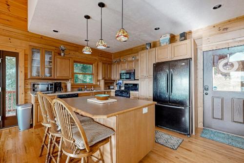 a kitchen with wooden cabinets and a black refrigerator at The Glen of Iron Duff in Waynesville