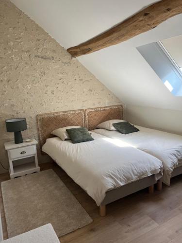 two twin beds in a attic bedroom with a window at Maison au bord de la Loire in Saint-Jean-le-Blanc