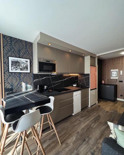 une cuisine avec une table et des chaises dans une pièce dans l'établissement Bel appartement neuf, proche Paris et Orly, à Savigny-sur-Orge