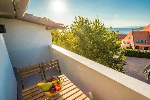 a bowl of fruit on a wooden bench on a balcony at Sunset Holiday3 in Njivice