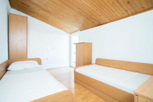 a bedroom with two beds and a wooden ceiling at Sunset Holiday3 in Njivice