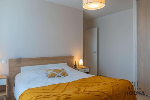 une chambre avec un grand lit avec une couverture jaune dans l'établissement Le Coquet - Aux cœur de Limoges - 371B, à Limoges