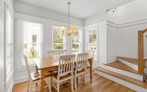 a dining room with a table and chairs and windows at Bimini by Oversee 30A in Carillon Beach