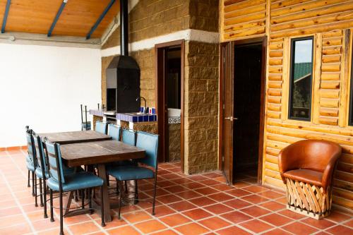 a kitchen with a wooden table and some chairs at Cabañas Bungalos las Alazanas in San Antonio de las Alzanas
