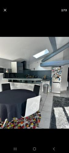 - une cuisine avec une table et une chaise blanche dans l'établissement Appart proche perolliere et gare Ouest Lyonnais, à Sain-Bel