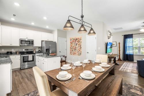 a kitchen and dining room with a wooden table and chairs at Charming 5bd - BBQ - Deck- 4mins Duke University in Durham
