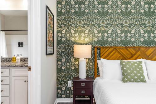 a bedroom with a bed and a green and gold wallpaper at Charming 5bd - BBQ - Deck- 4mins Duke University in Durham