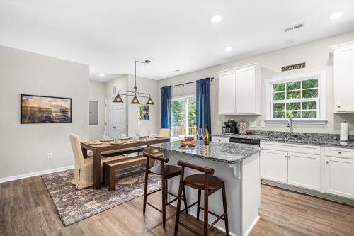 a kitchen and dining room with a table and chairs at Charming 5bd - BBQ - Deck- 4mins Duke University in Durham