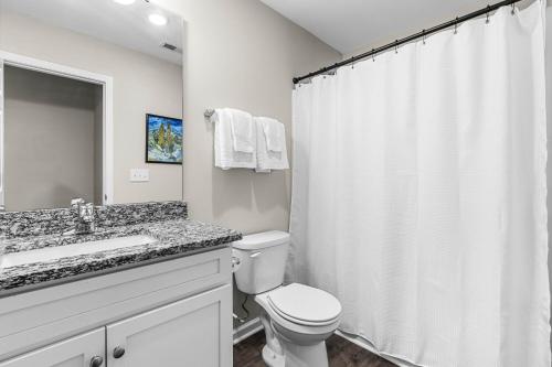 a white bathroom with a toilet and a shower at Charming 5bd - BBQ - Deck- 4mins Duke University in Durham