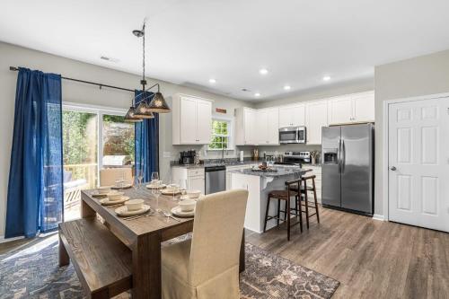 a kitchen and dining room with a table and chairs at Charming 5bd - BBQ - Deck- 4mins Duke University in Durham