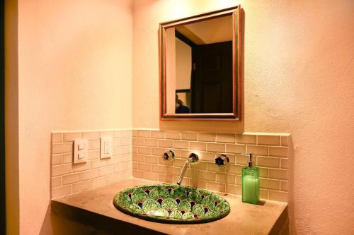 a bathroom with a green sink with a mirror at Prime Location, Fresh, Spotless, and Secure Accommodation in Sayulita