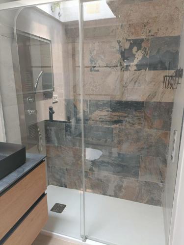 a bathroom with a glass shower with a sink at La Rueda, campo y playa en el Medano in El Médano