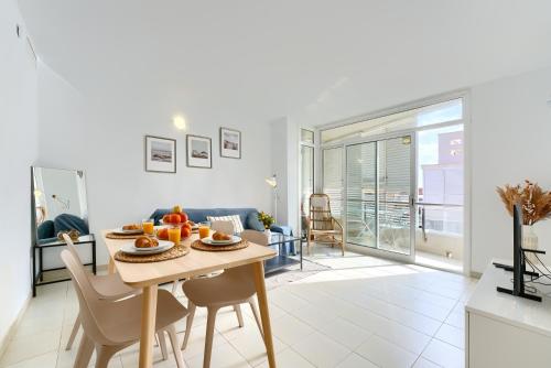 a kitchen and living room with a table and chairs at Pool&Beach Apartment Calafell by VM Group in Calafell