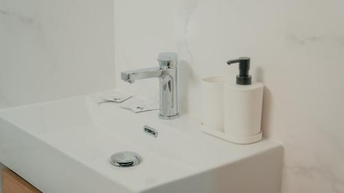 a white bathroom sink with a soap dispenser on it at CH Barco in Madrid