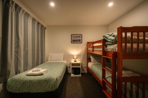 a small room with two bunk beds and a lamp at Nova Heights in Lake Tekapo