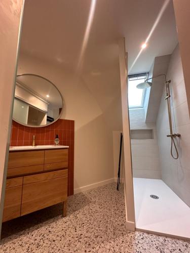 a bathroom with a shower and a sink and a mirror at Grand Appartement ultra moderne Plein Centre, plage à pieds, avec parking in Concarneau